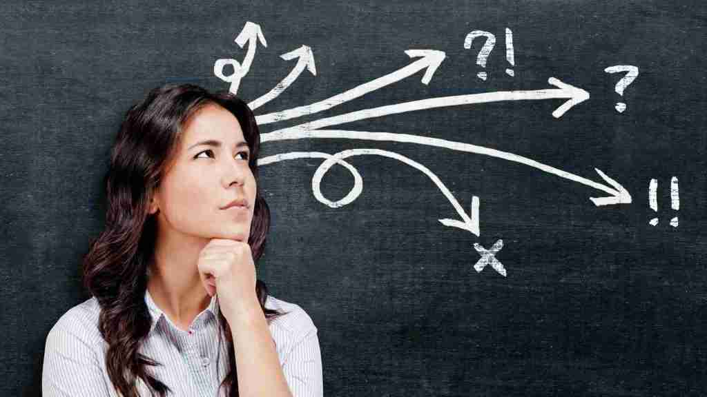 Woman thinking about a decision, standing in front of a blackboard with arrows on it