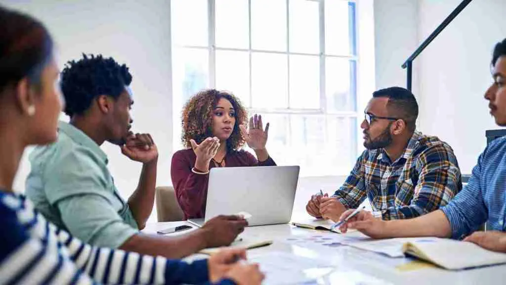 Diverse team around a meeting table, discussing a business decision